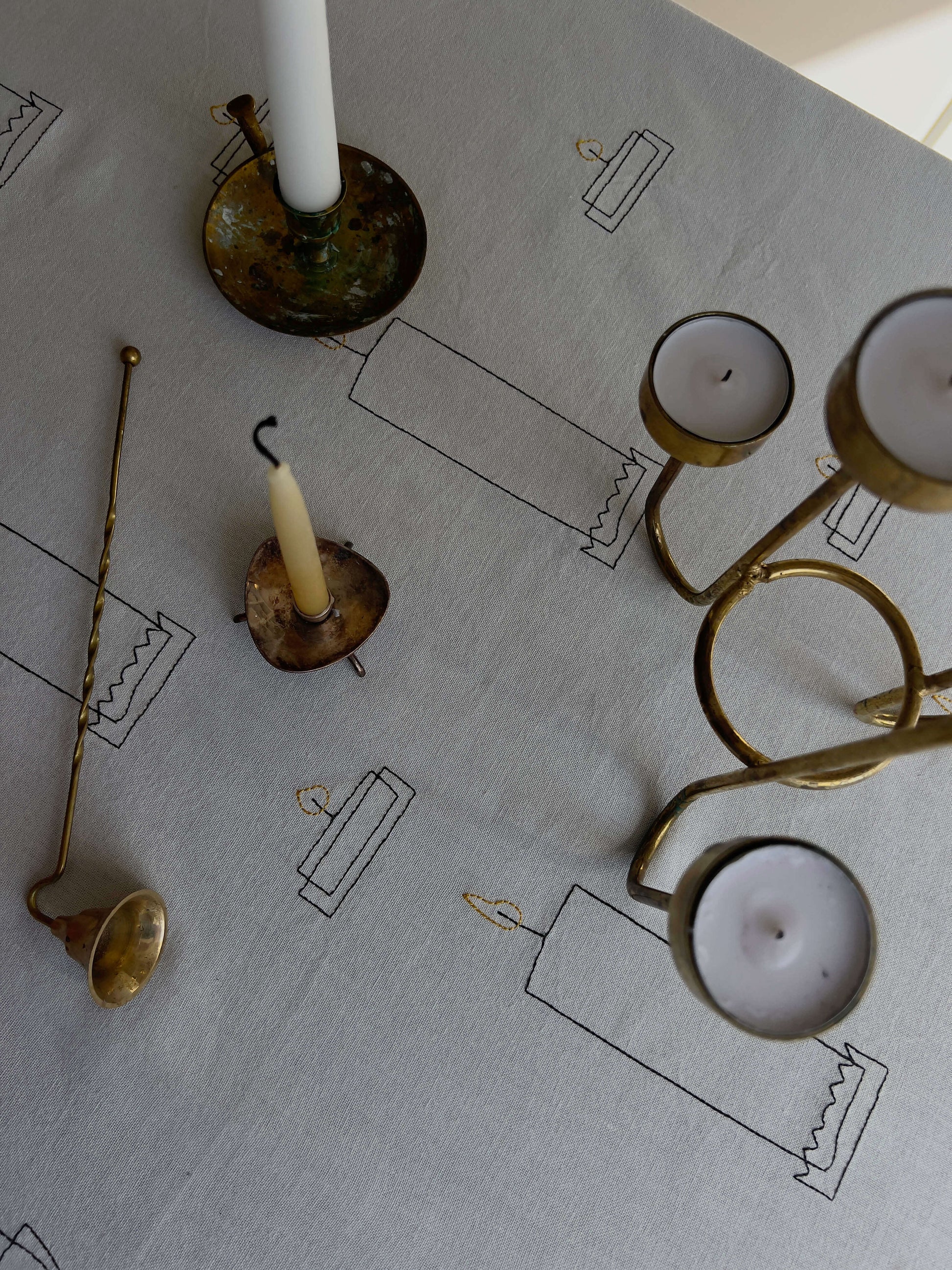Detalje af bordopdækning med Candlelight Dug og vintage-inspirerede lysestager.