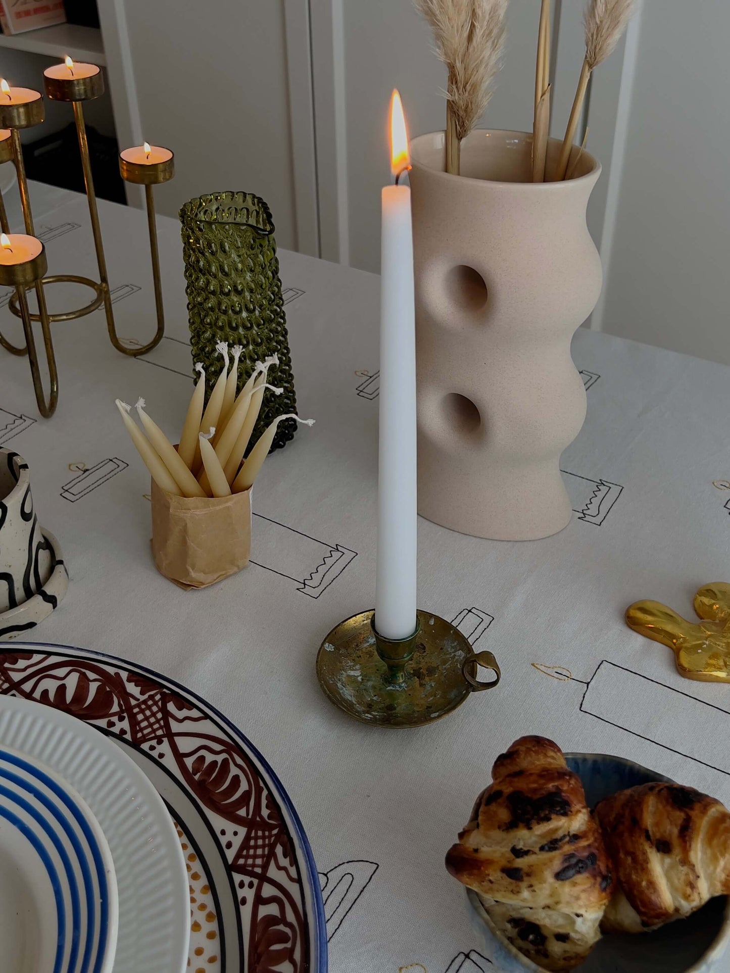 Detalje af bordopdækning med Candlelight Dug og vintage-inspirerede lysestager.
