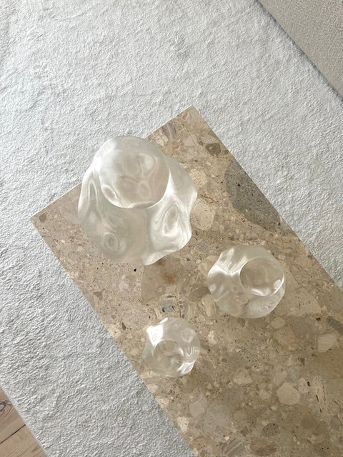 Illumina Vase i bæredygtigt materiale, placeret på et bord med små dekorative elementer, der understreger dens moderne og minimalistiske udtryk.