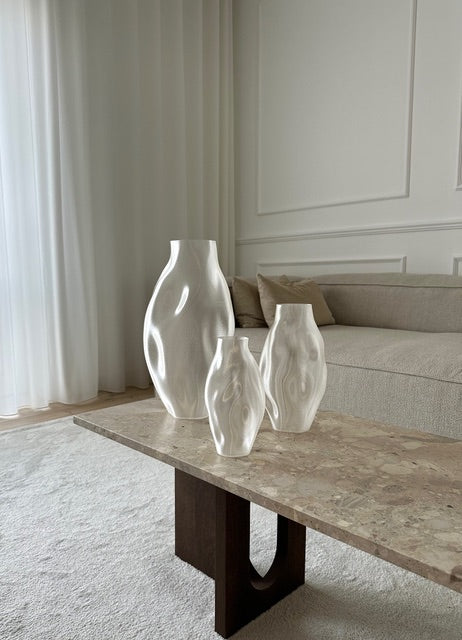 Illumina Vaser fra Essentia CPH i forskellige størrelser, stående side om side på et marmorbord, fremhævende deres skulpturelle design.