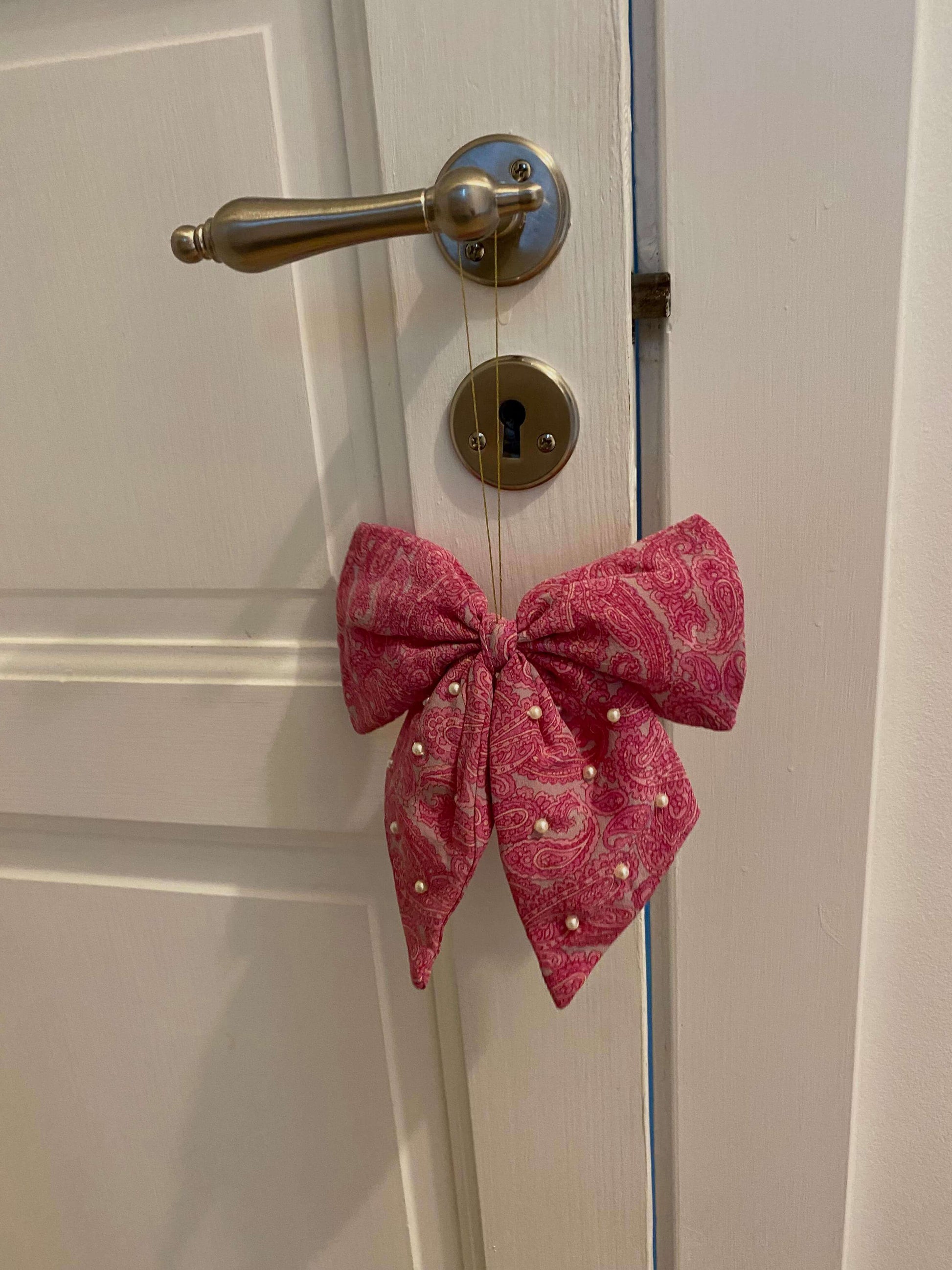 Rødt Bow Silk Ornament i upcycled silke, ophængt som elegant juledekoration.