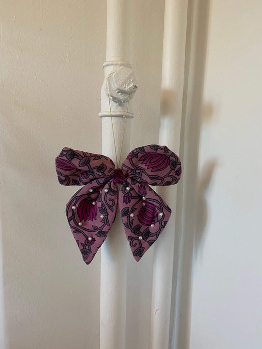 Bow Silk Ornament hænger som unik vægpynt – bæredygtigt og håndlavet.