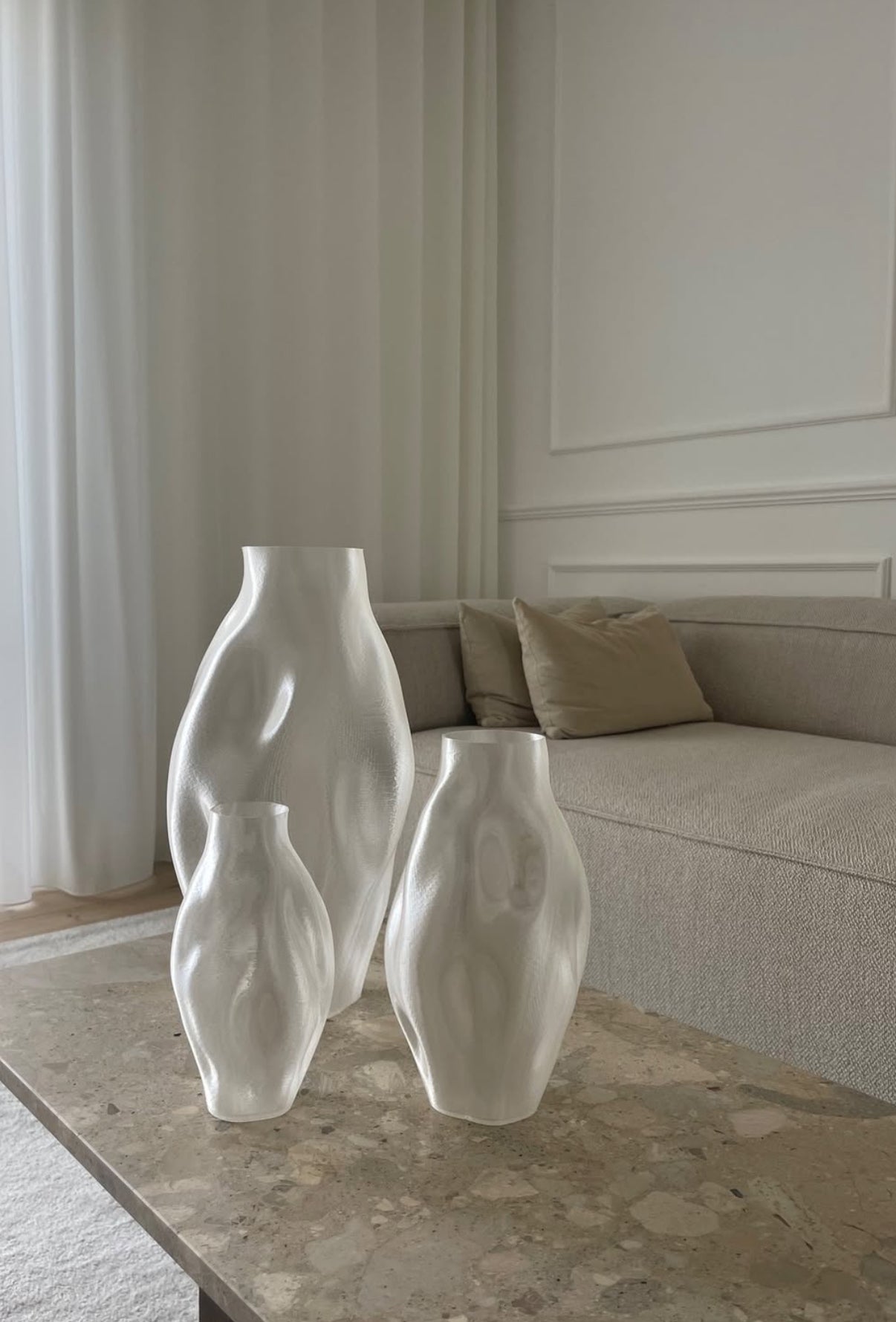 Illumina Vaser i bioplast placeret på et sofabord i en stilren og minimalistisk stue med neutrale farver og blødt lys.
