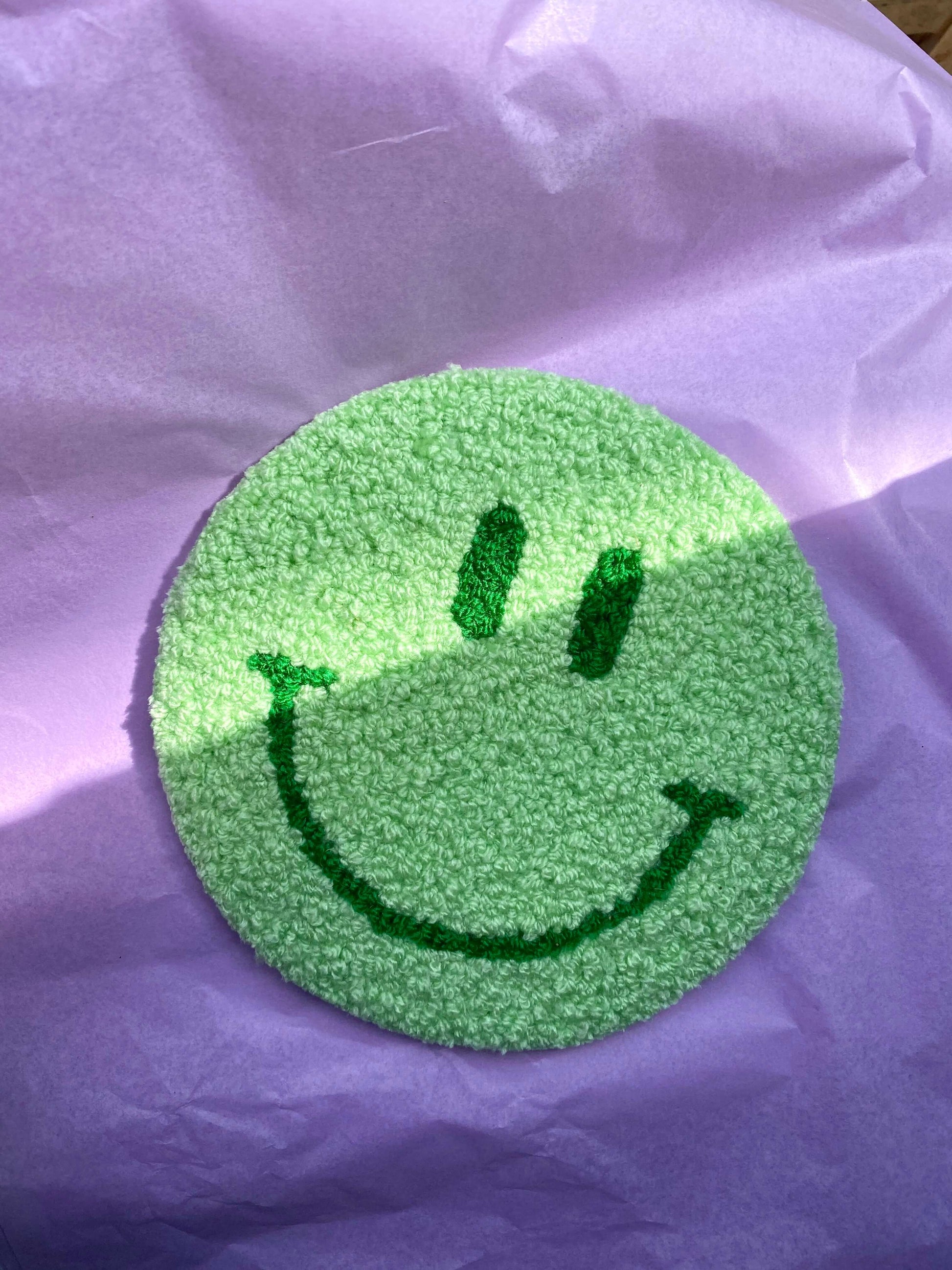 Grønt Smiley vægtæppe på lilla baggrund – håndlavet design fra @riisdesign.