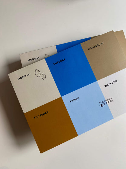 Blåmst madplan ved siden af notesblok